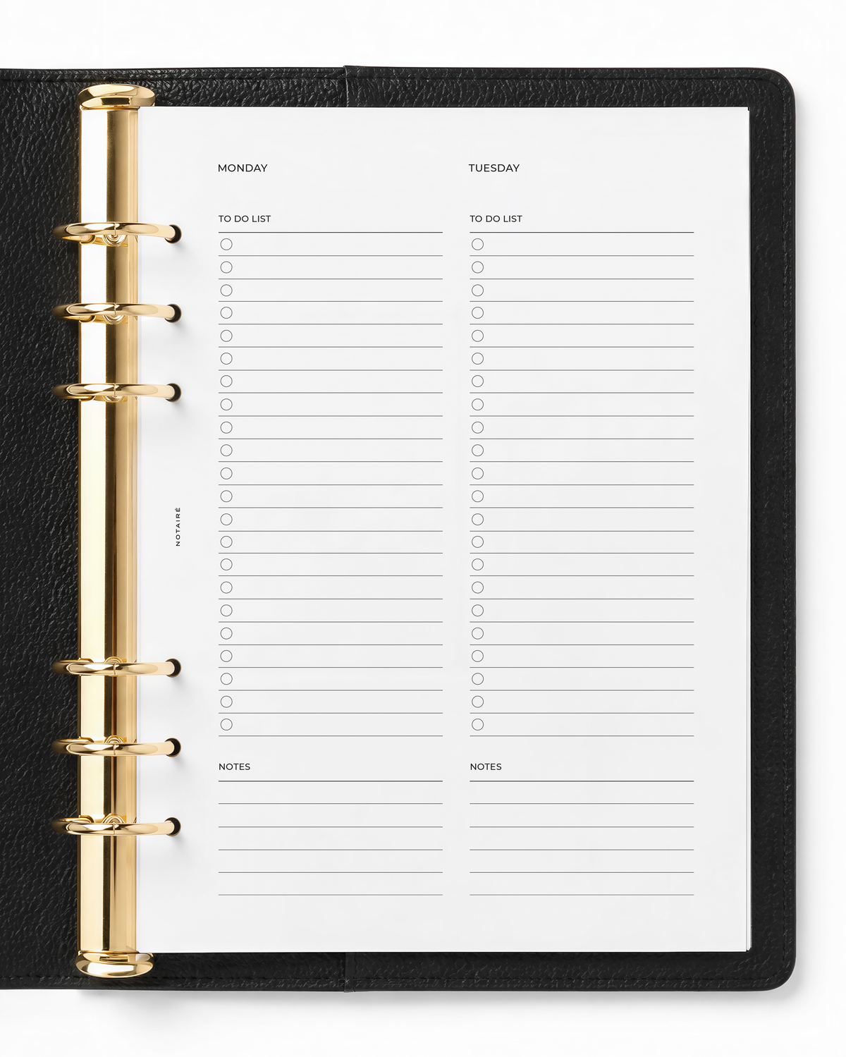 An open black leather-bound planner binder with gold-tone ring hardware, showing Notaire white daily planner pages labeled Monday and Tuesday with to-do lists and notes sections.