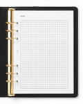 A black leather-bound ring binder notebook with gold-tone metal rings and a white Notairé grid graph paper insert page labeled NOTES.